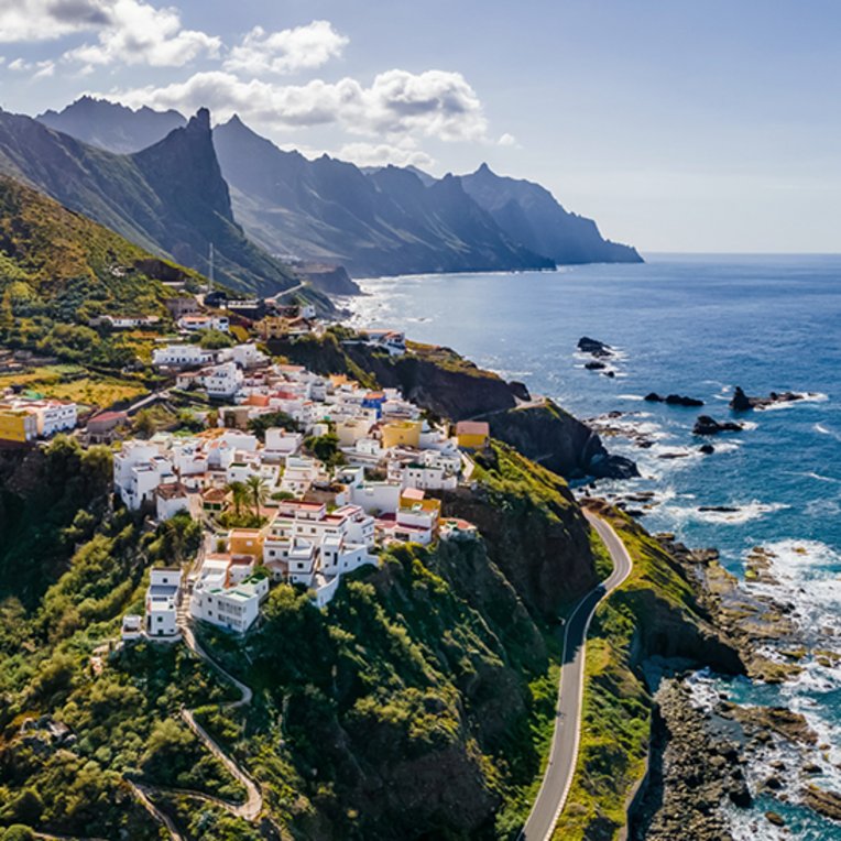  Luftaufnahme des Dorfes Cana auf der Insel Cana, Kanaren, Spanien, umgeben von grünen Hügeln und dem blauen Meer.
