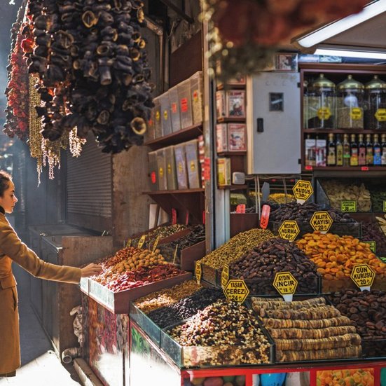 Eine Frau steht in Istanbul vor einem Obst- und Gemüsestand.