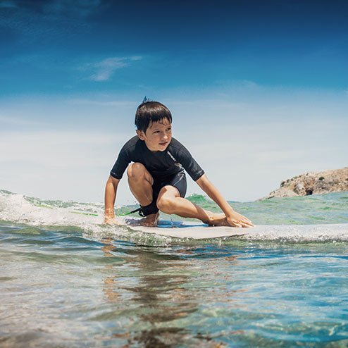 un petit enfant surfe dans la mer
