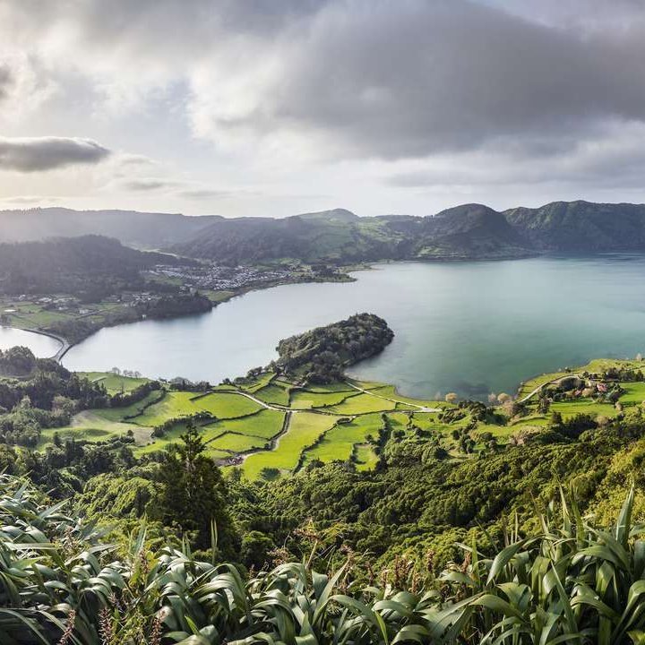 Die Azoreninseln mit üppigem Grün und klarem Wasser, umgeben von atemberaubenden Klippen und sanften Hügeln.