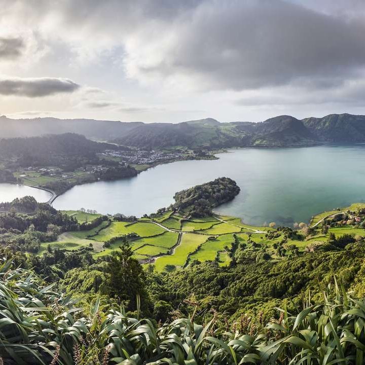 Die Azoreninseln mit üppigem Grün und klarem Wasser, umgeben von atemberaubenden Klippen und sanften Hügeln.