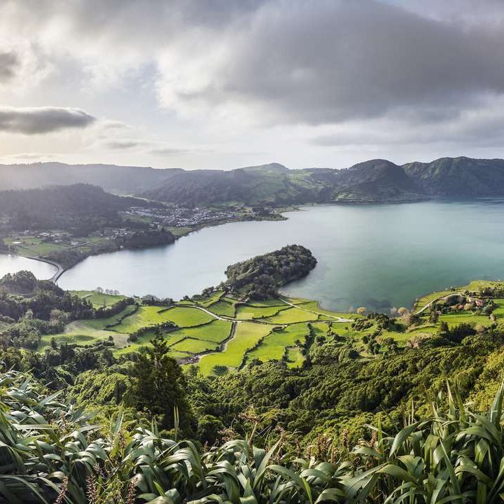 Die Azoreninseln mit üppigem Grün und klarem Wasser, umgeben von atemberaubenden Klippen und sanften Hügeln.