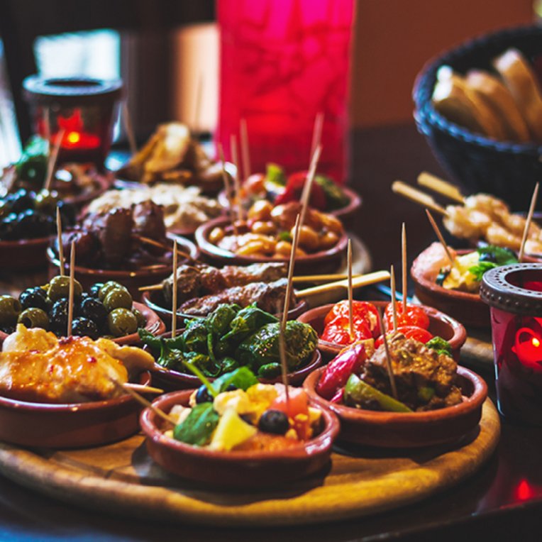  Ein Tisch voller köstlicher Tapas aus Barcelona, mit verschiedenen Gerichten und Snacks zum Teilen.