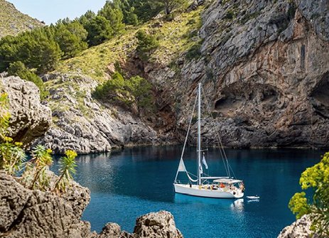 Ein Boot schwimmt in einem blauen Gewässer vor der Küste Mallorcas.