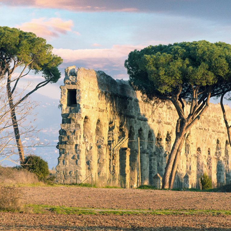  Das Kolosseum in Rom, Italien, umgeben von antiken Ruinen und dem Aquädukt.