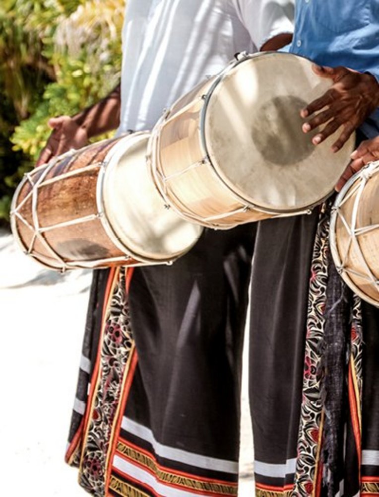 Un homme jouant du tambour en tenue locale aux Maldives