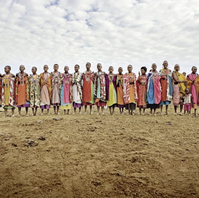 Menschen stehen in einem weiten Feld in Kenia, genießen die Natur und die Gemeinschaft.