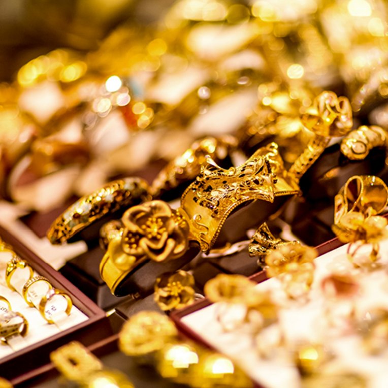  Eine Vitrine mit funkelndem Goldschmuck in Dubai, die verschiedene Ringe, Ketten und Armbänder zeigt.