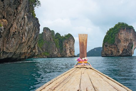 Ein Einbaum auf einem ruhigen Fluss in Asien, umgeben von üppiger Natur.