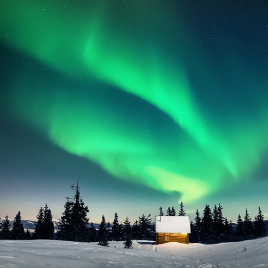 Nordlichter leuchten über einer verschneiten Hütte in Lappland.