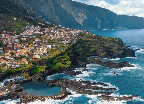 Blick von oben auf das Dorf São José auf der Insel São José in Portugal, umgeben von üppiger Natur und blauen Gewässern.