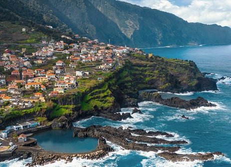 Blick von oben auf das Dorf São José auf der Insel São José in Portugal, umgeben von üppiger Natur und blauen Gewässern.