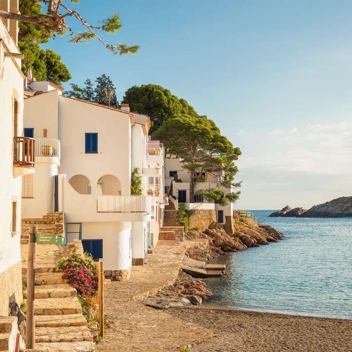 Une belle plage dans un petit village espagnol, entourée de douces vagues et d'un ciel ensoleillé.