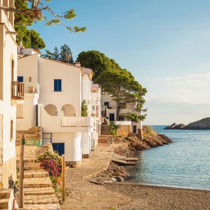 Ein schöner Strand in einem kleinen spanischen Dorf, umgeben von sanften Wellen und sonnigem Himmel.