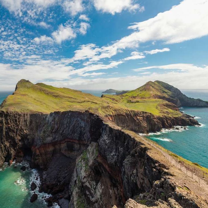 Klippen am Kap der Guten Hoffnung mit Blick auf das Meer und die beeindruckende Landschaft von Madeira im Hintergrund.