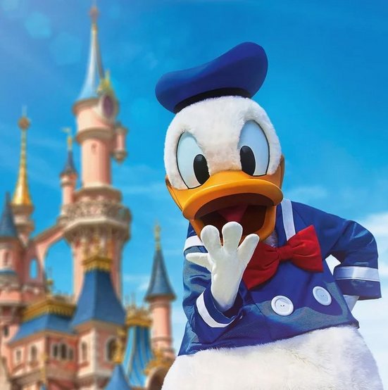 Donald Duck steht vor einem Schloss in Disneyland Paris, mit einem beeindruckenden Schloss im Hintergrund.