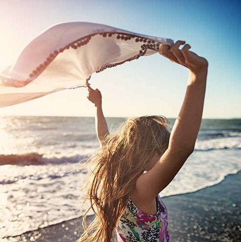 une fille libre sur la plage.