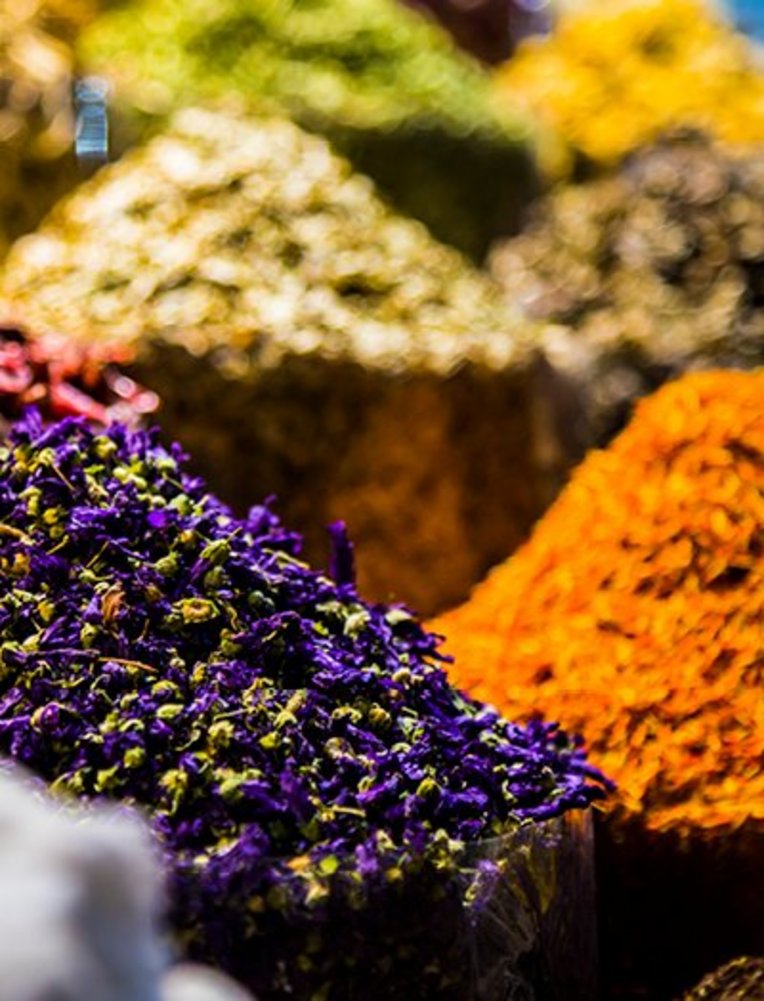 Eine Auswahl bunter Gewürze aus Dubai, die in kleinen Schalen präsentiert werden.