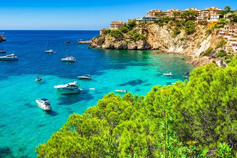 Schöne Bucht von Cala d'Or auf Mallorca mit klarem Wasser und malerischen Booten im Sonnenlicht.