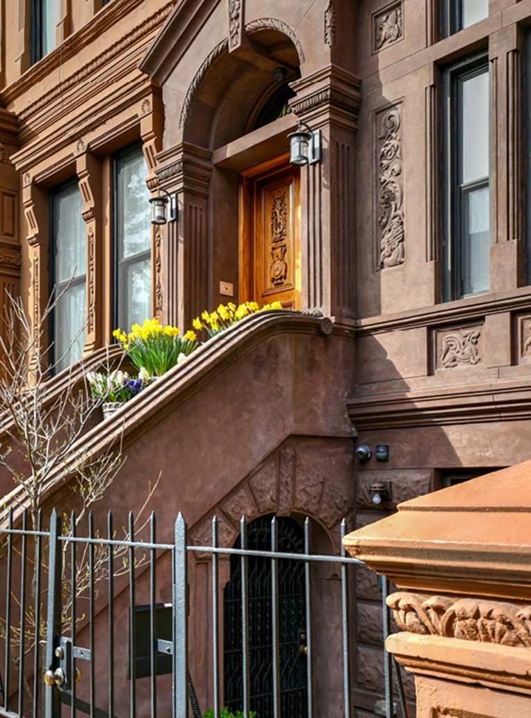 Braunes Gebäude mit einem grossen Eisenzäun in NYC.