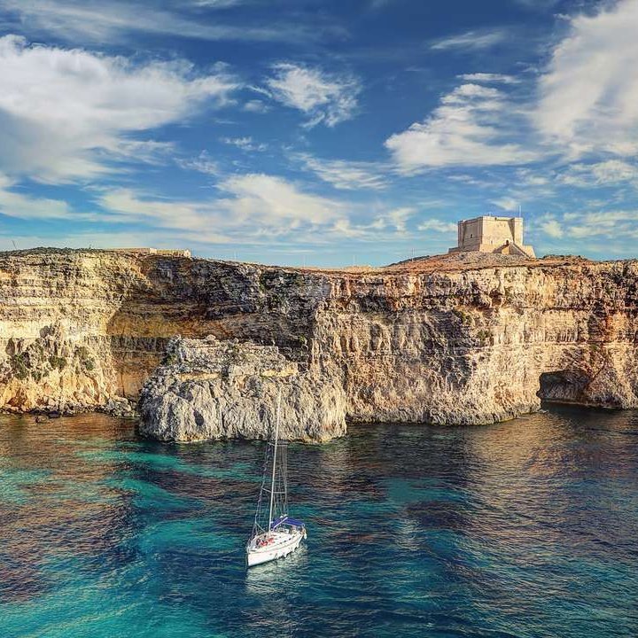 Paysage de Malte avec eaux cristallines, falaises calcaires et villes historiques.