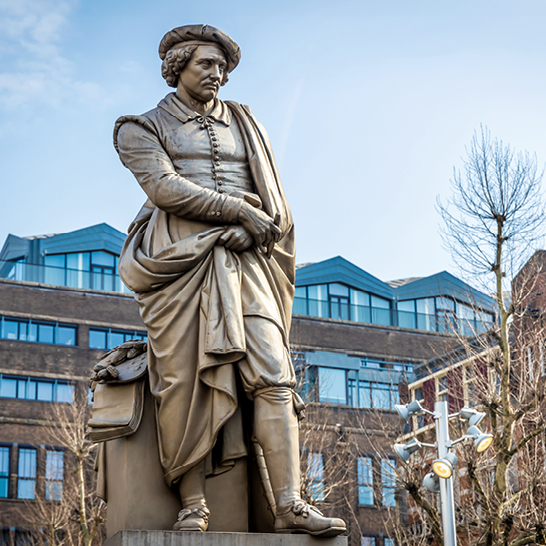 Statue eines Mannes mit einer Tasche auf der Schulter, aufgestellt in Amsterdam.