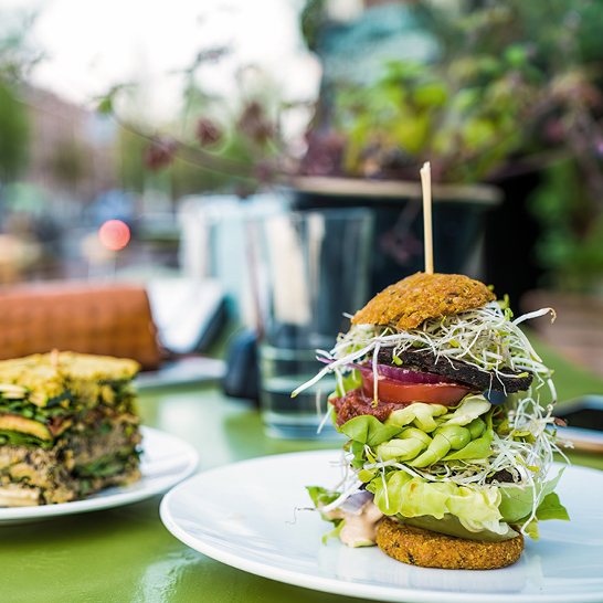 Ein Teller mit einem Burger und einem Salat auf einem Tisch in Amsterdam.