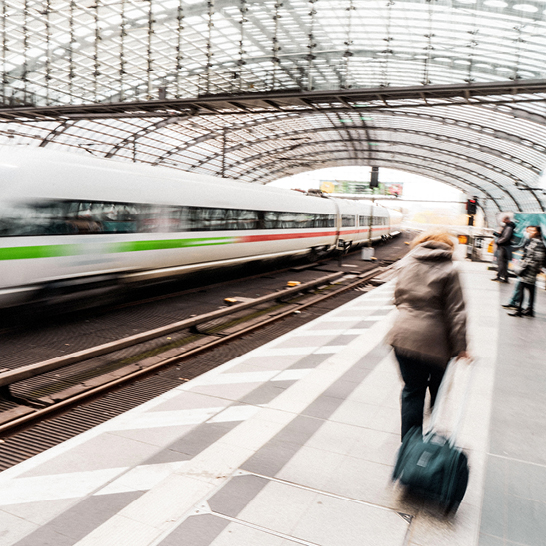 Eine Frau geht mit einem Koffer auf einem Bahnsteig in Berlin.