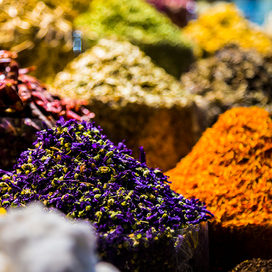 Eine Auswahl bunter Gewürze aus Dubai, die in kleinen Schalen präsentiert werden.