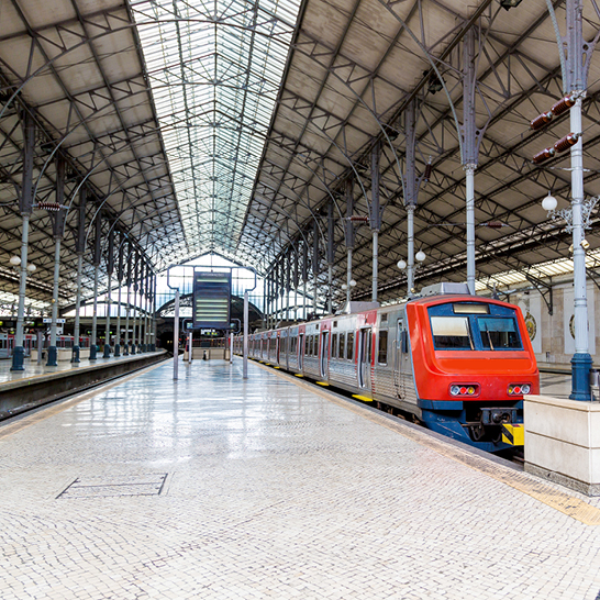 Ein Zug steht an einem überdachten Bahnhof in Lissabon.