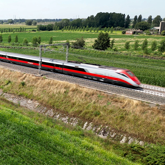 Ein Zug fährt über die Gleise in einer ländlichen Gegend, umgeben von Feldern und Bäumen.