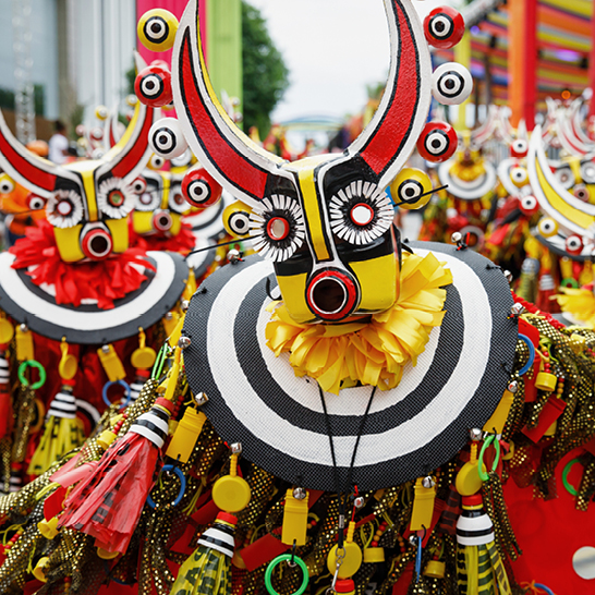 Eine Gruppe von Menschen in bunten Kostümen feiert die farbenfrohe Kultur der Dominikanischen Republik.