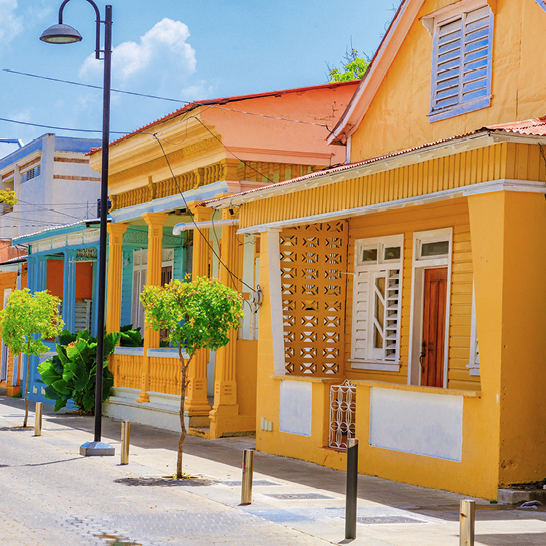 Eine Reihe von Häusern mit einem gelben Gebäude in der Mitte, aufgenommen in Puerto Plata, Dominikanische Republik.