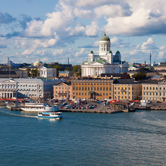 Ein Boot fährt den Fluss in Helsinki entlang, umgeben von malerischer Natur.