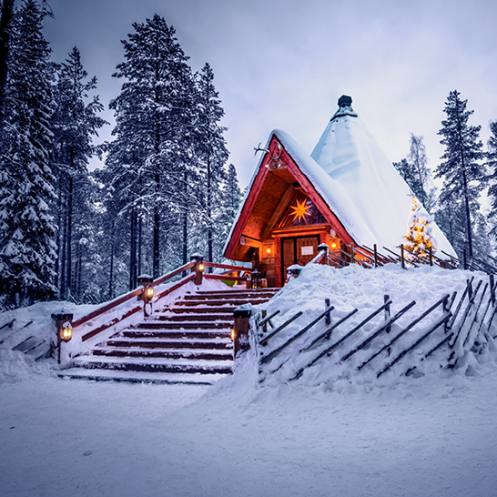 Eine kleine Hütte im Santa Claus Village, komplett mit Schnee bedeckt.
