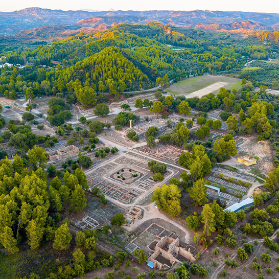 Luftaufnahme der antiken Stadt Olympia, mit Blick auf die Ruinen und die umliegende Landschaft.