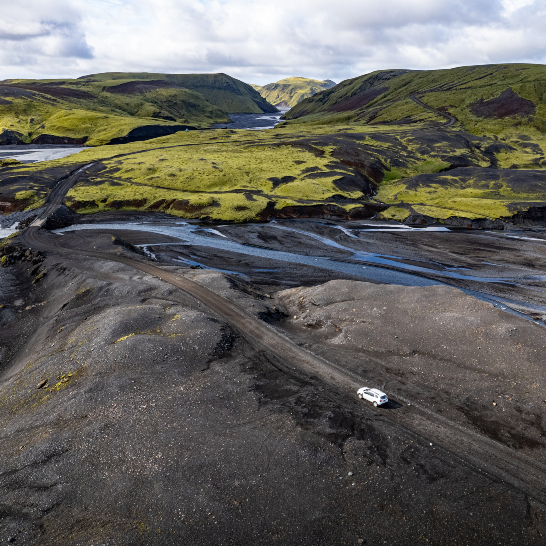 Ein weißer Truck fährt durch eine schwarze Landschaft.