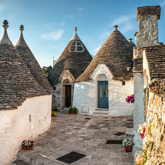 Trulli-Häuser in Alberobello, Apulien, Italien, mit ihren charakteristischen konischen Dächern und weißen Wänden.