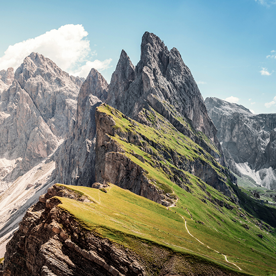 Bergkette der Dolomiten in Italien mit einer Straße, die sich entlang des Gipfels schlängelt.
