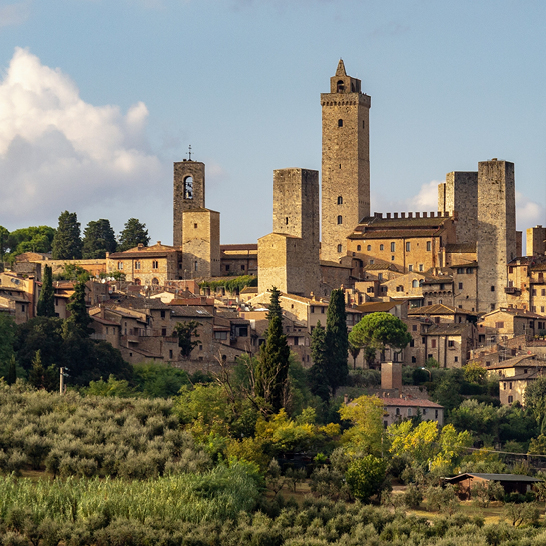 Eine grosse Stadt in der Toskana, Italien, mit einem markanten Uhrturm im Hintergrund.