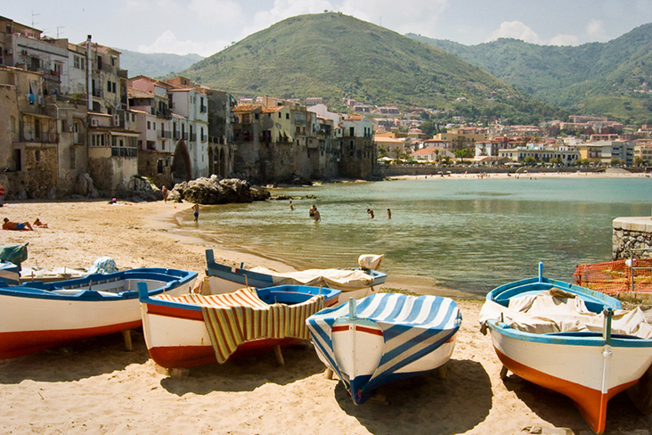 Eine Gruppe von Booten am Strand, umgeben von der italienischen Küstenlandschaft.