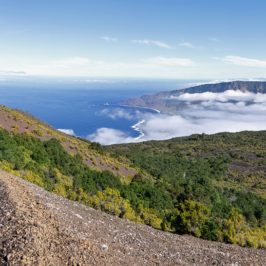 Schotterweg auf einem Hügel in El Hierro, umgeben von Natur und mit Blick auf die Landschaft.