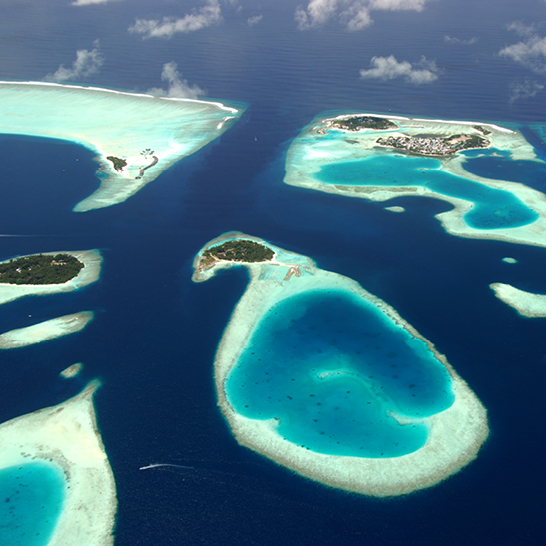 Weitläufiges Wasser in den Malediven, das sanft in der Sonne glitzert.Himmel.