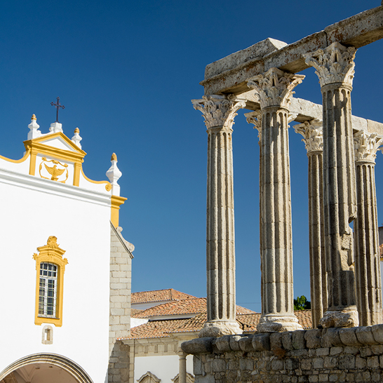 Ein historisches Gebäude mit eleganten Säulen und einem auffälligen Uhrturm, das die Umgebung dominiert.