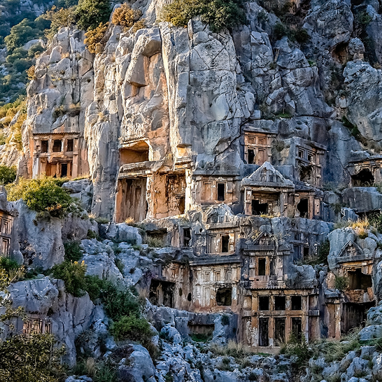 Alte Häuser in der Türkei entlang des Lykischen Weges, umgeben von grüner Natur und beeindruckenden Bergen.