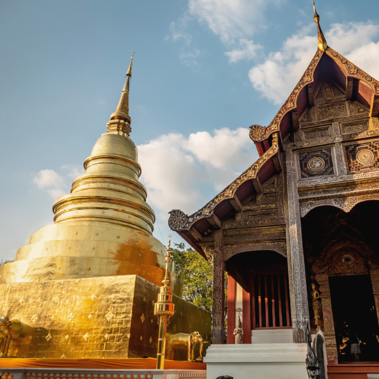 Grosses goldenes Gebäude mit hohem Turm, das die spirituelle Atmosphäre Thailands verkörpert.