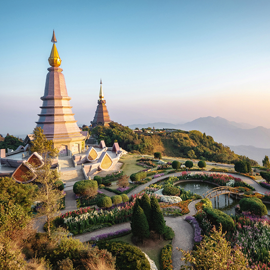 Wunderschöne Pagoden in Chiang Mai, Thailand, umgeben von üppigem Grün und klarem blauen Himmel.
