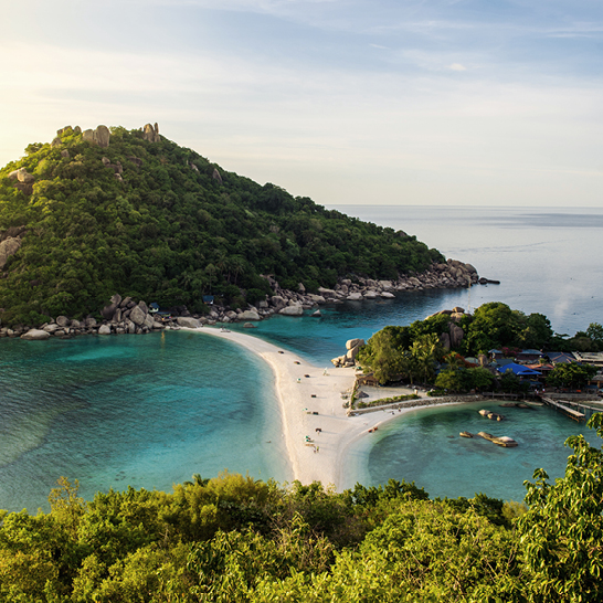 Wunderschöner Strand mit einer kleinen Insel in der Mitte, typisch für die Paradiesinseln in Thailand.