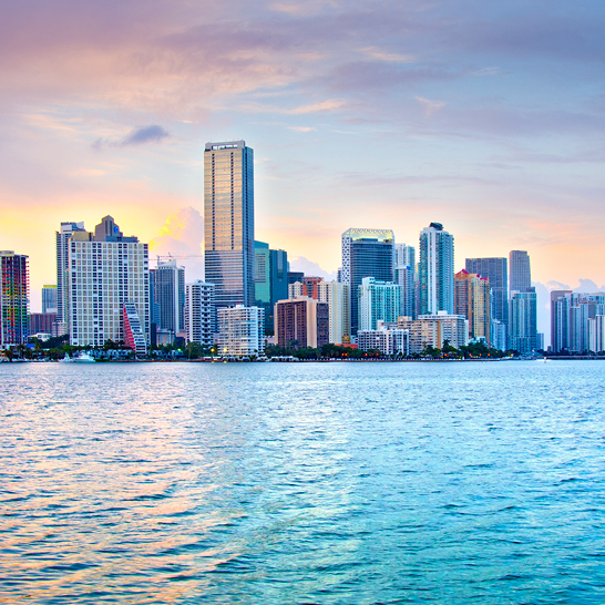 Stadtansicht mit hohen Gebäuden und Wasser, repräsentiert ikonische Städte der USA.