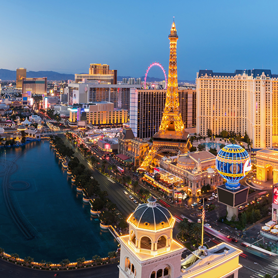Blick auf den Las Vegas Strip bei Dämmerung, mit leuchtenden Lichtern und lebhafter Atmosphäre.